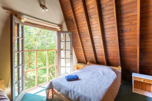 a bedroom with a bed in front of a window at Cabañas Rio Hermoso in Cerro Negro