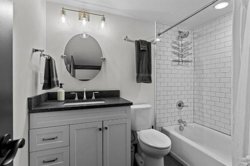 a bathroom with a sink and a toilet and a mirror at Riverfront Studio - Walk to Arch, Casino and Conventions in Minutes in Saint Louis