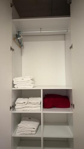 a white closet with white towels and a red pillow at Cilveti 468 departamento con cochera, excelente ubicación in Rosario