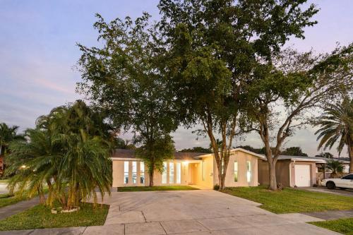 a house with trees in front of it at 4BR Hollywood Villa 3 min to Beach, Heated 12-Person Jacuzzi, Game Room and BBQ in Hollywood