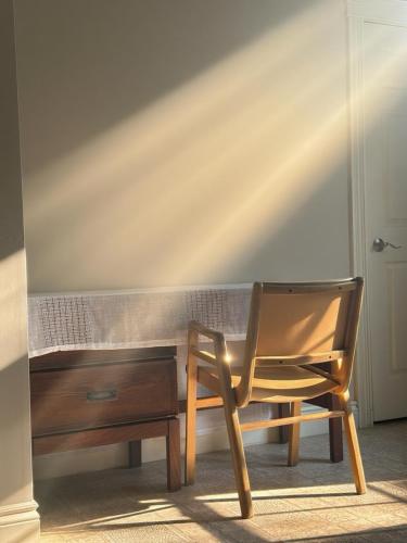 a wooden desk with a chair next to a table at EcoSun Hostel - Female-Only in Georgetown
