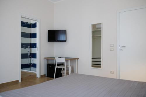 a bedroom with a bed and a desk and a tv at Maison Marechiara in Castellammare di Stabia