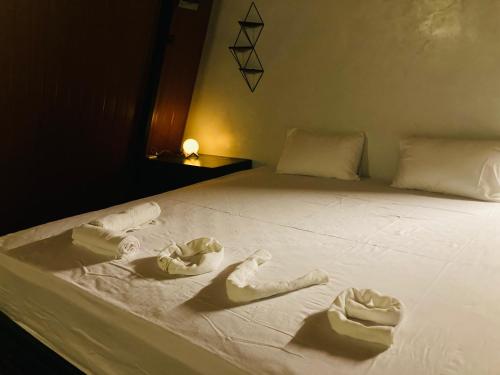 a bed with white sheets and towels on it at Motel Vintage Beliatta in Beliatta