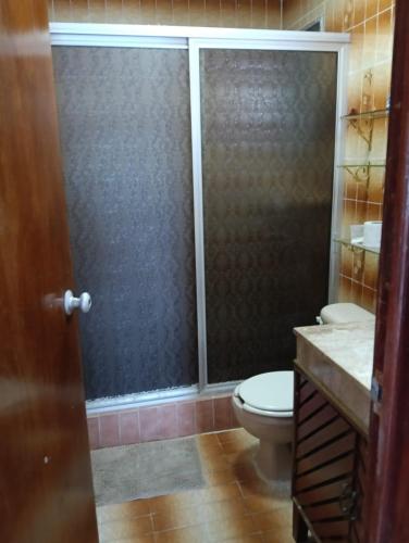 a bathroom with a toilet and a glass shower door at Departamento FRENTE al MAR in Progreso