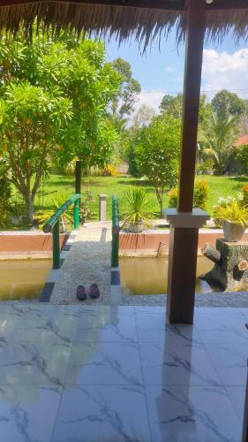 a view of a swimming pool with trees and bushes at Leuser inn in Bukit Lawang