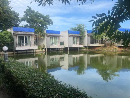 a building next to a body of water at Blue Palm Resort in Bang Sare