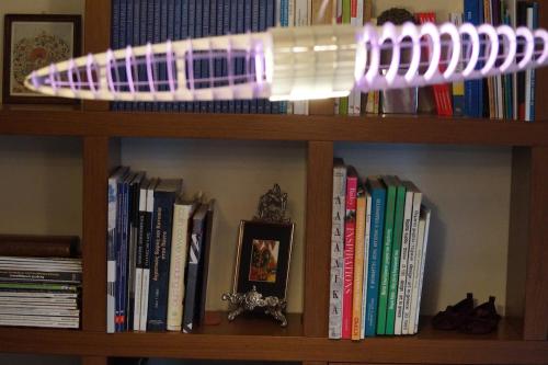 a book shelf with books and a purpleppelin on it at Infinite blue Horizon Elegance Hospitality in Epanomi