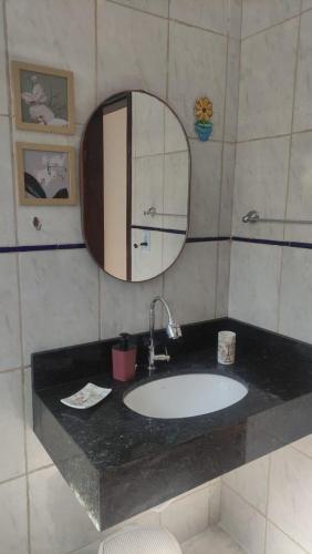 a bathroom with a sink and a mirror at Pousada Flor do Campo in Lavrinhas