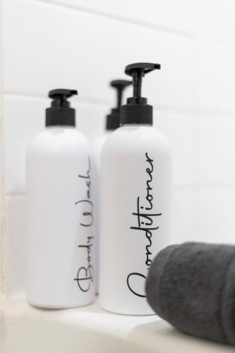 a group of three bottles of soap and a brush at Olive Oasis Retreat - Walkout to Pool & Hot Tub! in Tempe Junction