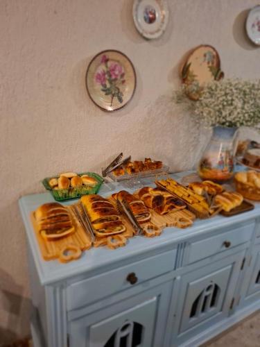 einen Tisch mit einem Haufen Gebäck und anderen Lebensmitteln in der Unterkunft Pousada Casa de Vó in Diamantina