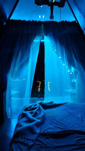 a bedroom with a bed with blue lights in it at Flora Glamping de Abuela in Fortuna