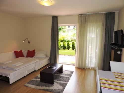 a living room with a bed and a sliding glass door at Alpe-Adria Apartments in Oberaichwald