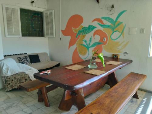 ein Wohnzimmer mit einem Holztisch und Bänken in der Unterkunft Casa gourmet vista para o mar in Ilhabela