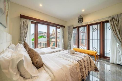 a large bedroom with two beds and large windows at Modern 5BR Luxury Villa with Pool & Rooftop - 100m from Sanur Beach in Sanur