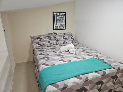 a bedroom with a bed with a green blanket on it at Loft Nicolau Garcia in São José