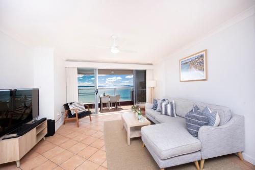 a living room with a couch and a television at El Sandi, Unit 10, 14-18 North Street in Forster