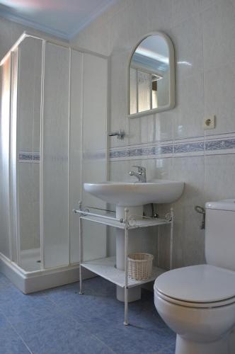 a bathroom with a sink and a toilet and a mirror at El Balcón de Onís in La Robellada de Onis