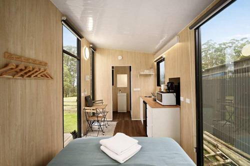 a room with a bed and a kitchen with a window at High on a Mountain Top by Tiny Away in Koornalla