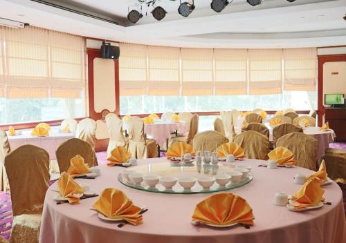 a banquet hall with tables and chairs and tablesktop at Grand Palace Hotel in Miri