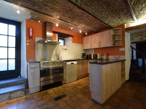 a large kitchen with a stove and a sink at Gouvy Forest Farmhouse in Gouvy