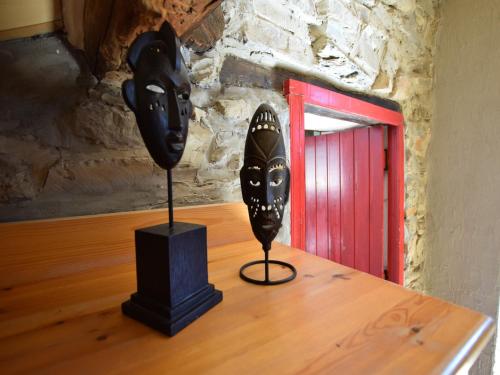 two black masks sitting on top of a wooden table at Gouvy Forest Farmhouse in Gouvy