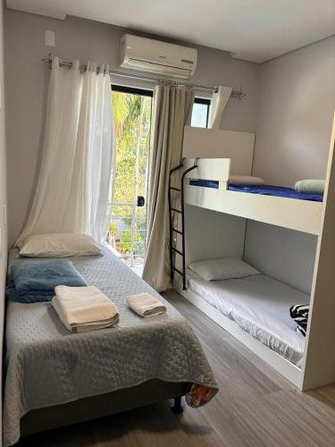 a bedroom with two bunk beds and a window at Casa Joinville in Joinville