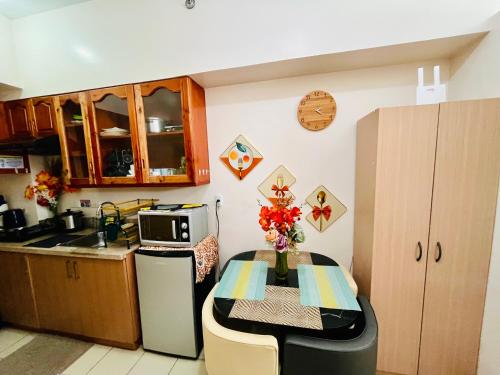 eine kleine Küche mit Tisch und Mikrowelle in der Unterkunft JAZZCOZY Condo Unit na SWAK SA BUDGET in Baguio City