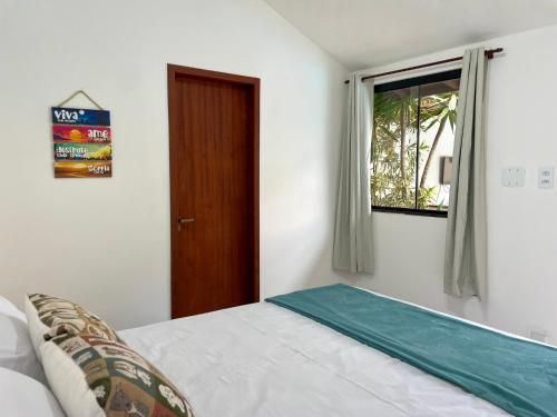 a bedroom with a bed and a window at Do Adriano Suites in Búzios