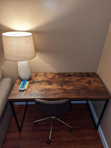 a wooden table with a lamp and a chair at STADIUM LUXURY - CONDO for 4 STEPS AWAY FROM SOFI in Inglewood