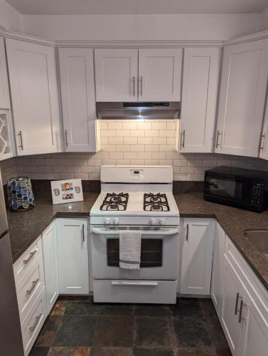 a kitchen with a white stove and white cabinets at STADIUM LUXURY - CONDO for 4 STEPS AWAY FROM SOFI in Inglewood