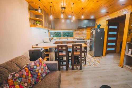 a kitchen and living room with a couch and a table at Casa 38 en Condominio Piscina climatizada 5 pax in Pichilemu