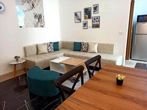 a living room with a couch and a table and chairs at Wahat Serenity S1 Appart équipé avec parking privé & wifi entre Tunis et La Marsa in Tunis