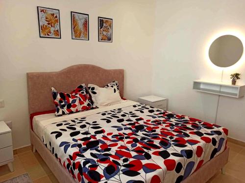a bedroom with a bed with a black and white comforter at Wahat Serenity S1 Appart équipé avec parking privé & wifi entre Tunis et La Marsa in Tunis