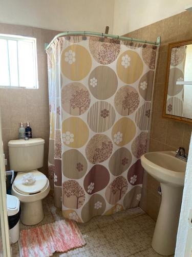 a bathroom with a toilet and a shower curtain at Casa Arena in Lo de Marcos