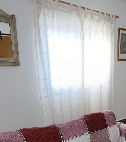 a white curtain in a room with a window at Cruz del Sur in Santa Rosa