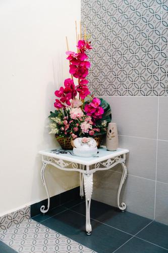 a table with flowers and candles on top of it at Villa Cinta Jasmeen in Kuala Kangsar