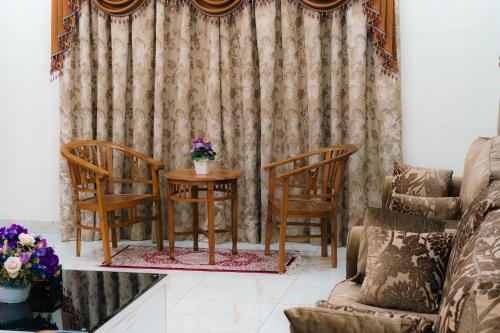 a living room with two chairs and a table at Villa Cinta Jasmeen in Kuala Kangsar