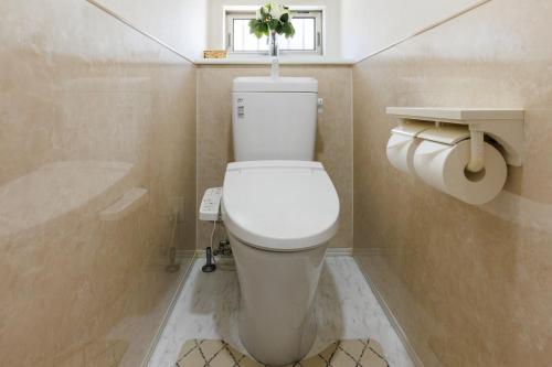 a bathroom with a white toilet with a window at Seaside Villa Itoman in Itoman