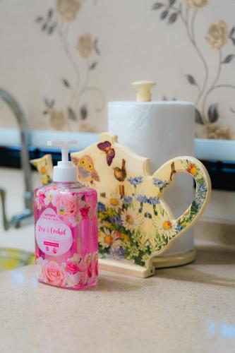 a bottle of soap sitting next to a vase at Villa Cinta Jasmeen in Kuala Kangsar