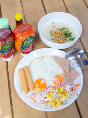 a table with a plate of food with eggs and vegetables at เดอะเบสแคปซูล รีสอร์ท in Ban Tha Manao