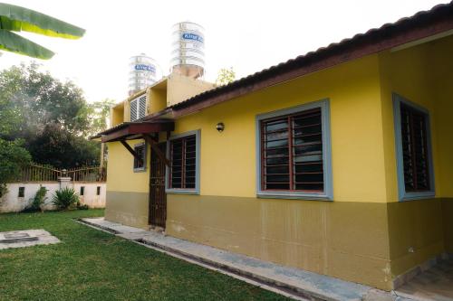 a yellow house with a lighthouse in the background at Villa Cinta Jasmeen in Kuala Kangsar
