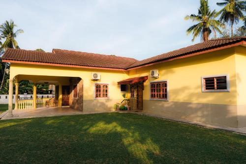 a house with a green lawn in front of it at Villa Cinta Jasmeen in Kuala Kangsar