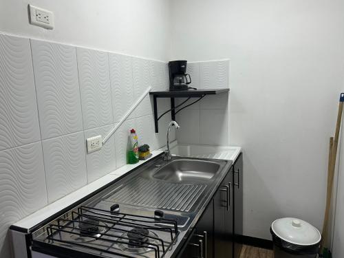 a kitchen with a sink and a stove at Apartamentos FM 202 in Líbano