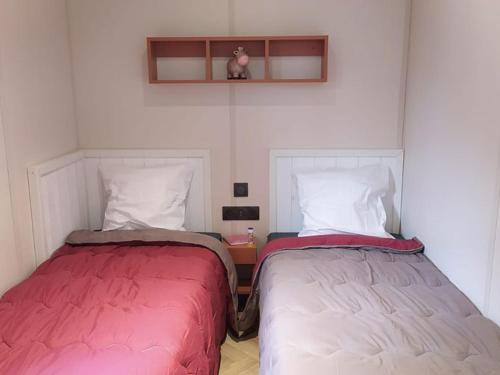 Dos camas una al lado de la otra en una habitación. en Chalet spacieux avec terrasse pour 6 personnes - API-1-52-482, en Saint-Maime