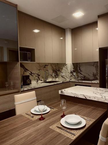 a kitchen with two plates and wine glasses on a table at Luxury Apartment Leparc Residences in Quito