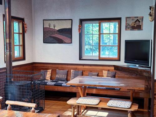 a living room with a couch and a television at Ringo Lodge Hakuba in Hakuba