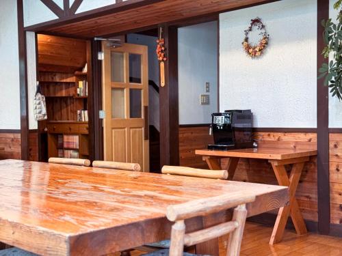 a large wooden table in a room with two tables at Ringo Lodge Hakuba in Hakuba