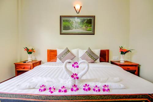 a white bed with a heart made out of towels at Thonka Boutique in Siem Reap