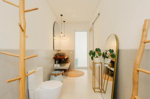 ein Badezimmer mit Toilette und Spiegel in der Unterkunft Namera Hidden Moon - 1 BR Brand New Villa in Kerobokan