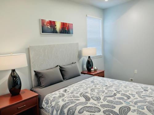 a bedroom with a bed and two lamps and a window at Hollywood Boutique Residences with Free Parking in Los Angeles